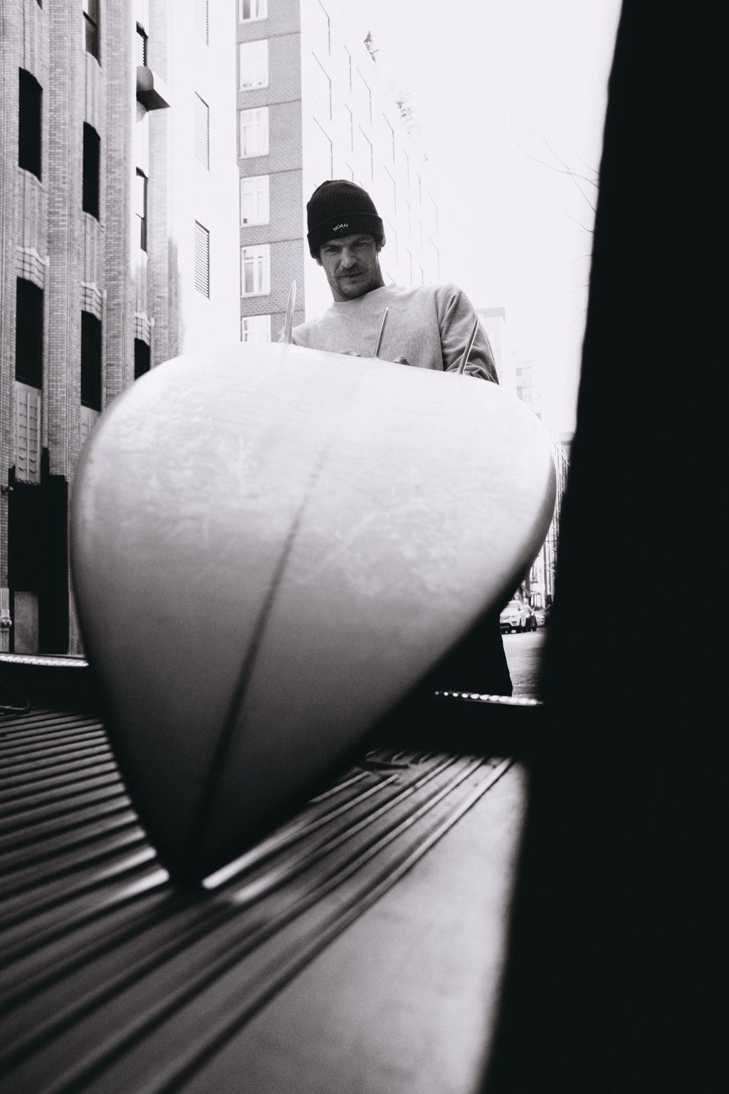Surfer holding a board toward the camera