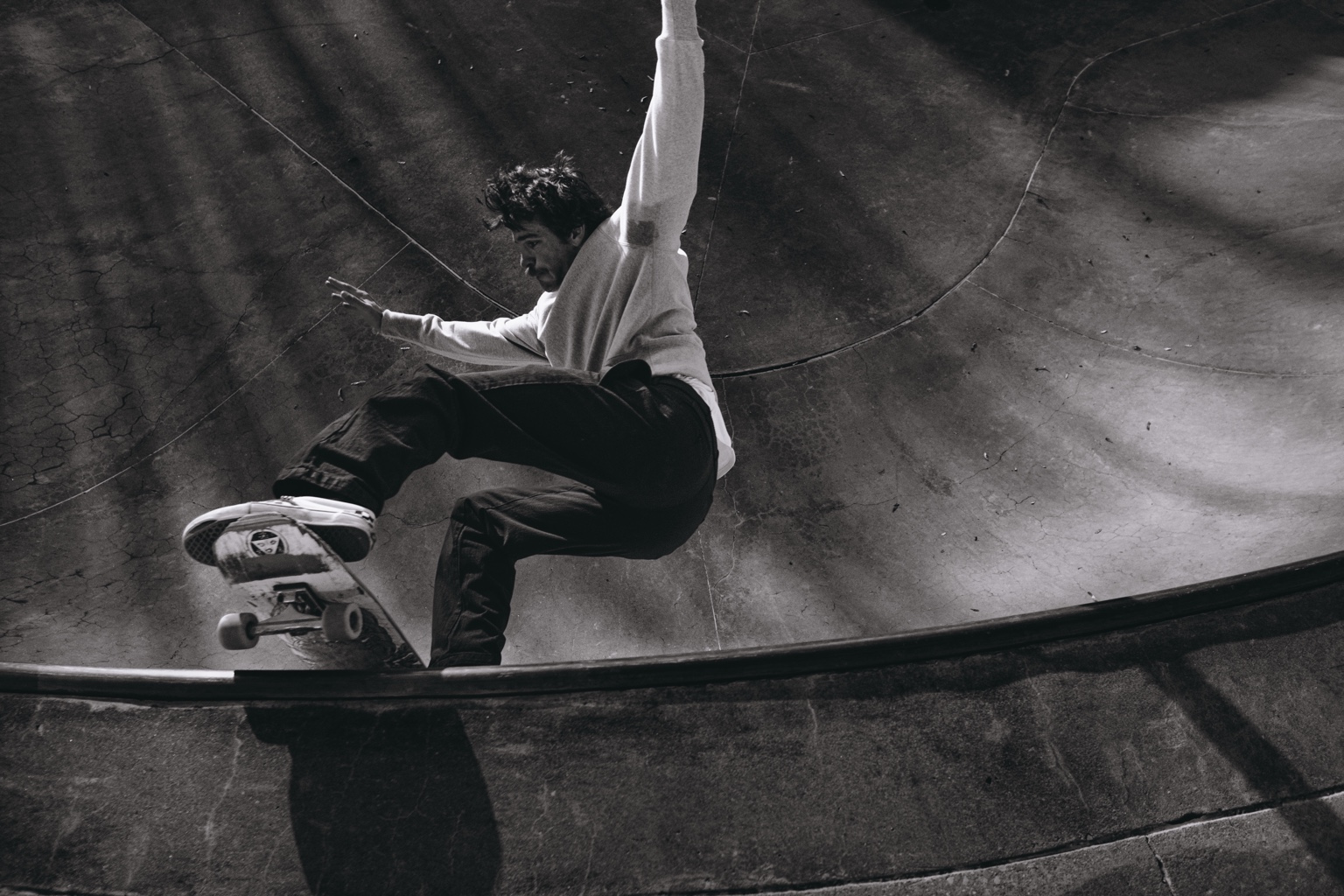 Skateboarder carving through a concrete bowl